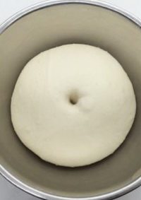 香蒜面包结,将面团揉至扩展，盖保鲜膜发酵2倍大。