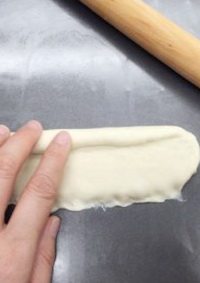 香蒜面包结,翻面后横放，压薄下面的一边，自上而下卷起。