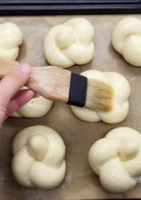 香蒜面包结,发酵好的面包坯入预热好的烤箱烤6-7分钟至基本定型后取出刷蒜香黄油一次。