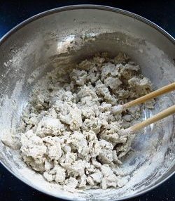 砂锅莜面鱼鱼,莜面面粉加入开水，用筷子搅拌均匀。