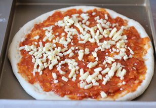 金枪鱼披萨,撒上一层马苏里拉奶酪。