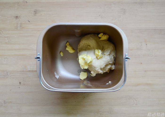 蓝莓泡浆小面包,选择面包机的和面程序，让面包机自动揉面15分钟，停机后加入黄油。