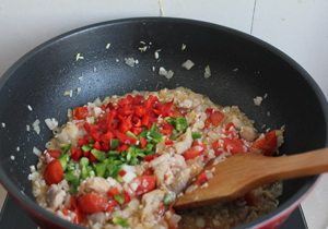 西班牙海鲜饭,放入青红椒碎，炒匀，把藏红花的颜色和香味炒出来，放盐和白胡椒粉调味。