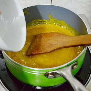 法式芒果软糖,一直小火熬煮果泥至接近沸腾，锅的四边出小泡泡时，往里加入剩余的80克白糖和水饴，轻搅均匀。