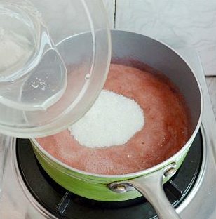 法式草莓软糖,草莓果泥倒入锅里小火加热至微温约40度时，往里拌入苹果胶白糖混合物，轻搅融化。