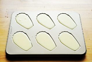 贝壳小蛋糕 ,将面糊挤入不沾贝壳模中，沾的模具需要刷一层黄油撒一层粉