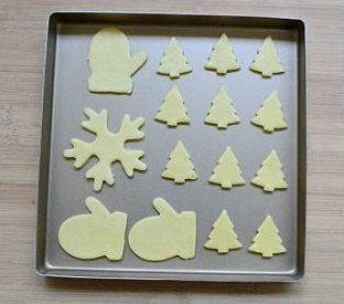 圣诞糖霜饼干,剪开保鲜袋的一面，用饼干模刻出形状，整齐的排放在铺了不粘油纸的烤盘上。