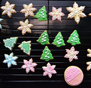 圣诞糖霜饼干,将拌匀的蛋白糖霜加入各色色素，分别放进裱花袋里，剪出一个小口，在饼干上画上相应的图案。