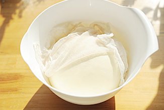 奶酪包,将揉好的面团整圆，表面铺一层湿布，盖上保鲜膜室温发酵至原来的2倍大；