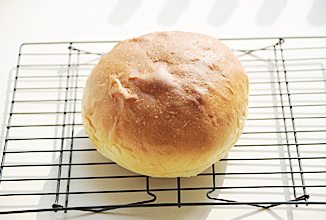 奶酪包,烤箱预热180℃，下层烘烤40分钟，中层加盖锡纸防止面包上色过重，烤好后取出趁热在面包表面刷上一层黄油，并将面包移入烤网晾凉；