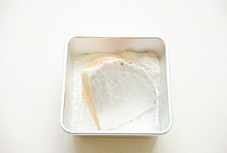 奶酪包,将抹上奶酪的两面放入奶粉和糖粉的混合粉中沾满粉；