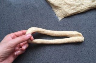 老式全麦面包,将分出的面坯搓成长条，将长条形的面坯对折，中间套在左手上
