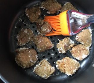 盐酥鸡,裹好淀粉的鸡肉块排在空气炸锅的烤网上，用刷子淋少许食用油在鸡块表面
