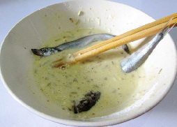 酥香多春鱼,将腌制好的多春鱼放入煎炸糊中有，沾满粉糊。