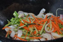 DIY炒拉条,再次烧热油锅下入圆葱、尖椒、胡萝卜都微微翻炒盛出