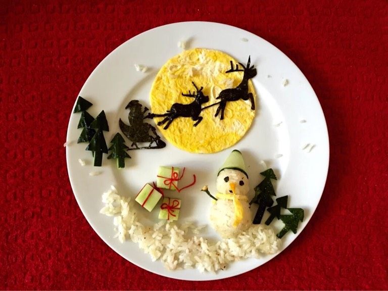 圣诞节餐盘画,如图将剩余米饭铺于盘底做雪地装饰，撒一些零散的米粒做雪花装饰。热闹的圣诞节餐盘画，浓浓的圣诞节氛围有木有。