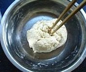 霍州干面饸饹,面团用筷子搅拌成团状后，手沾剩余的水，手一边沾水一边揉面团。