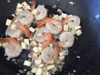 泰式炒河粉,加入虾，大约翻炒1-2分钟，直至虾壳开始变红，虾肉变白，把它铲到锅一边，同时放入河粉。