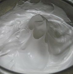 菊花纸杯蛋糕,将糖水倒入打至干性发泡的蛋白中继续用打蛋器打至可以形成立体状态。提起打蛋器可以出现弯的尖角即可。