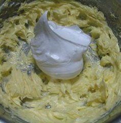 菊花纸杯蛋糕,先加入1/3的蛋白，用橡皮刮刀搅拌均匀。