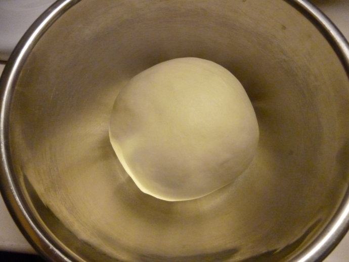 奶酪红豆面包,发酵完成（手指沾高粉戳入面团，凹洞不回弹或是缓慢回弹）后，均分成8份，分别滚圆后松弛15分钟。