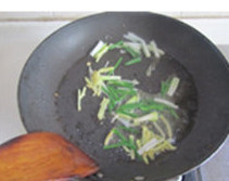 面拖蟹,锅中留底油，用中火加热，放入葱末和姜末煸炒出香味