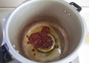 卤藕回锅牛肉,锅中放入适量的油，下入豆瓣酱翻炒