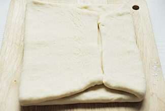 丹麦吐司,案板撒手粉，面团上也撒手粉，将面团擀成1cm左右的长方形，左侧面皮向右侧折一大半，右侧向左侧折，与折过来的左侧相接；