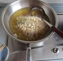 松鼠桂鱼 ,放到锅中，先用筷子进行固定炸，定形。左手固定好鱼尾巴。稍定形后，把热油淋在鱼肉上。火不要大，中火。捞出后倒出油，锅中留少许的油。
