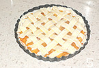 简易版黄桃派,条状的饼皮交叉编好盖在表面，并刷上蛋液