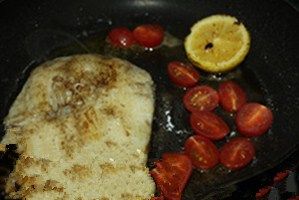 黄油香煎银鳕鱼,放入小番茄，同时将煎好的鱼肉和柠檬先装盘，小番茄煎至表皮变软即可，最后根据自己的口味再撒上适量罗勒碎、盐调味。