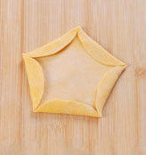 梅花蒸饺,擀好皮后，其中一面多粘点干面粉，朝上平铺，往上折起5个边