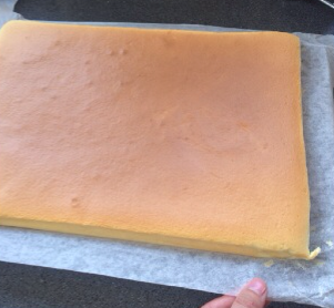 日式棉花蛋糕卷,烘焙完成后，立即将蛋糕片连同油纸拖出，将油纸四周揭开散热