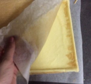日式棉花蛋糕卷,将蛋糕片倒扣在另一张油纸上，揭下底部油纸散热