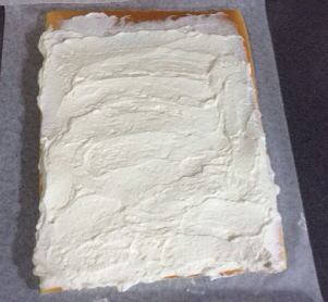 日式棉花蛋糕卷,将晾凉至微温的蛋糕片纵向放置，切去上下两端不整齐的边缘部分，起始端奶油要多一点，尾端薄一些，末端留2CM空白不要涂奶油