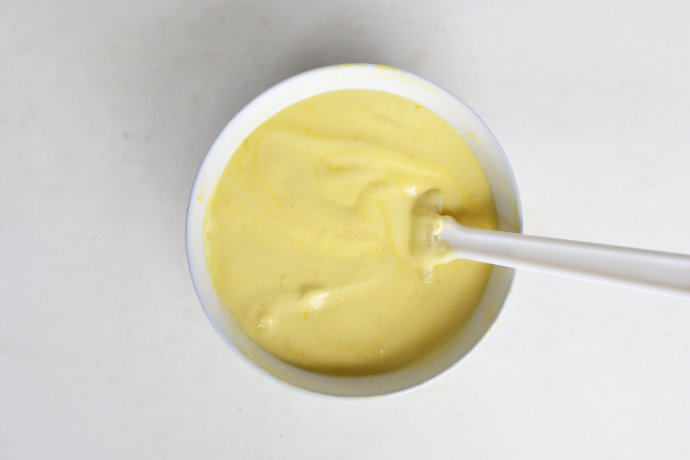 香橙柠檬戚风,取三分之一蛋白霜加入蛋黄糊中，翻拌均匀