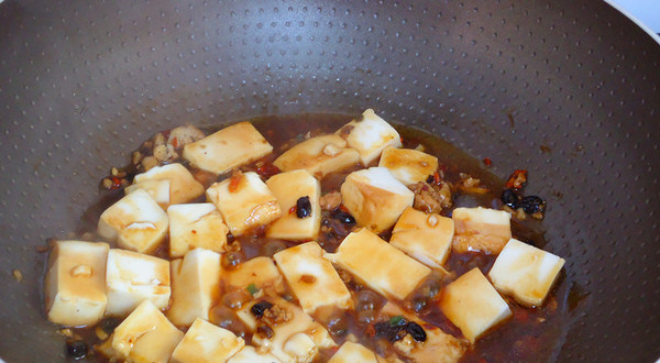 香辣豆腐,放入料酒、酱油、盐、加入适量的水，轻轻炒均，煮沸