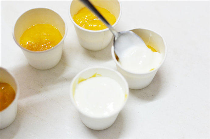 芒果酸奶迷你小冰棒,再勺入浓稠型酸奶覆盖于芒果泥上