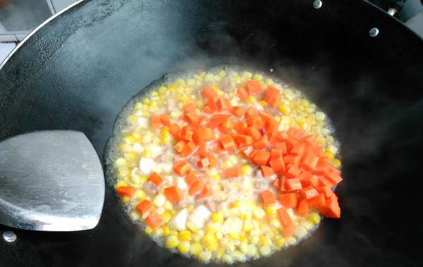 松子玉米,加入红萝卜粒。盖上锅盖继续煮两分钟