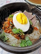 韩国冷面,牛肉摆放在面条上，放韩国泡菜，鸡蛋，沿着碗的边缘慢慢倒入冰镇的牛肉汤