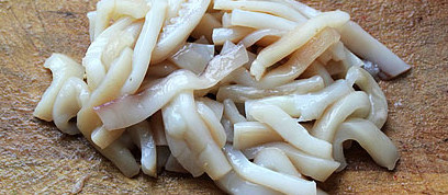 韩式鱿鱼拌面,剥去鱿鱼表面的薄膜，将鱿鱼切成圈状，然后再改刀成条状