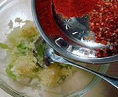 韩国腌黄瓜,把捣好的蒜蓉、姜蓉和苹果蓉倒入料理盆，里面放入干辣椒粉和干辣椒碎