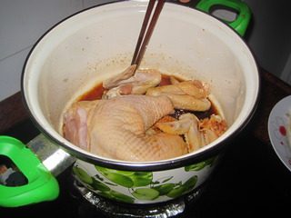 豉油鸡,把鸡肉放入锅内使每块鸡肉上都沾上酱汁。