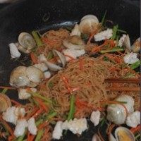 海鲜炒米粉,放一些鸡精调味，倒入前面炒好的鱿鱼卷，翻炒均匀即可出锅。