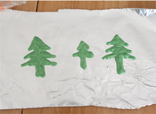 圣诞巧克力蛋糕,少量白巧克力放入裱花袋，在热水里融化，加入少量绿色色素，调成绿色的巧克力，画出圣诞树的形状放凉。