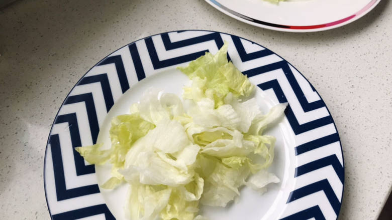 鸡胸肉蔬菜沙拉,同时手撕西生菜，放进餐盘；