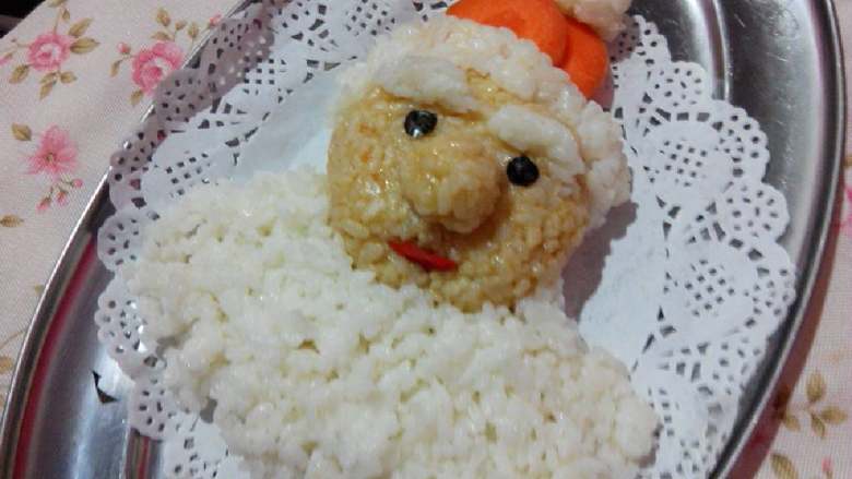 圣诞老人,剩下的白米饭全部匀称的铺在脸型下面，圣诞老人的胡须就制作好了。