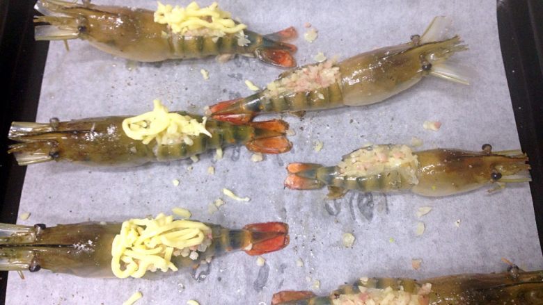 芝士焗大虾,用手指撑开虾背，小勺子把菜料塞进虾背，再铺上芝士碎。