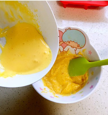 南瓜蛋黄米糕,打好的蛋黄倒入搅拌好的南瓜大米粉里