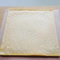 小黄人蛋糕卷,烤好的蛋糕，稍稍冷一下不烫手就要脱模。铺一层油纸在下面，扣在上面。把底部油纸撕掉即可。